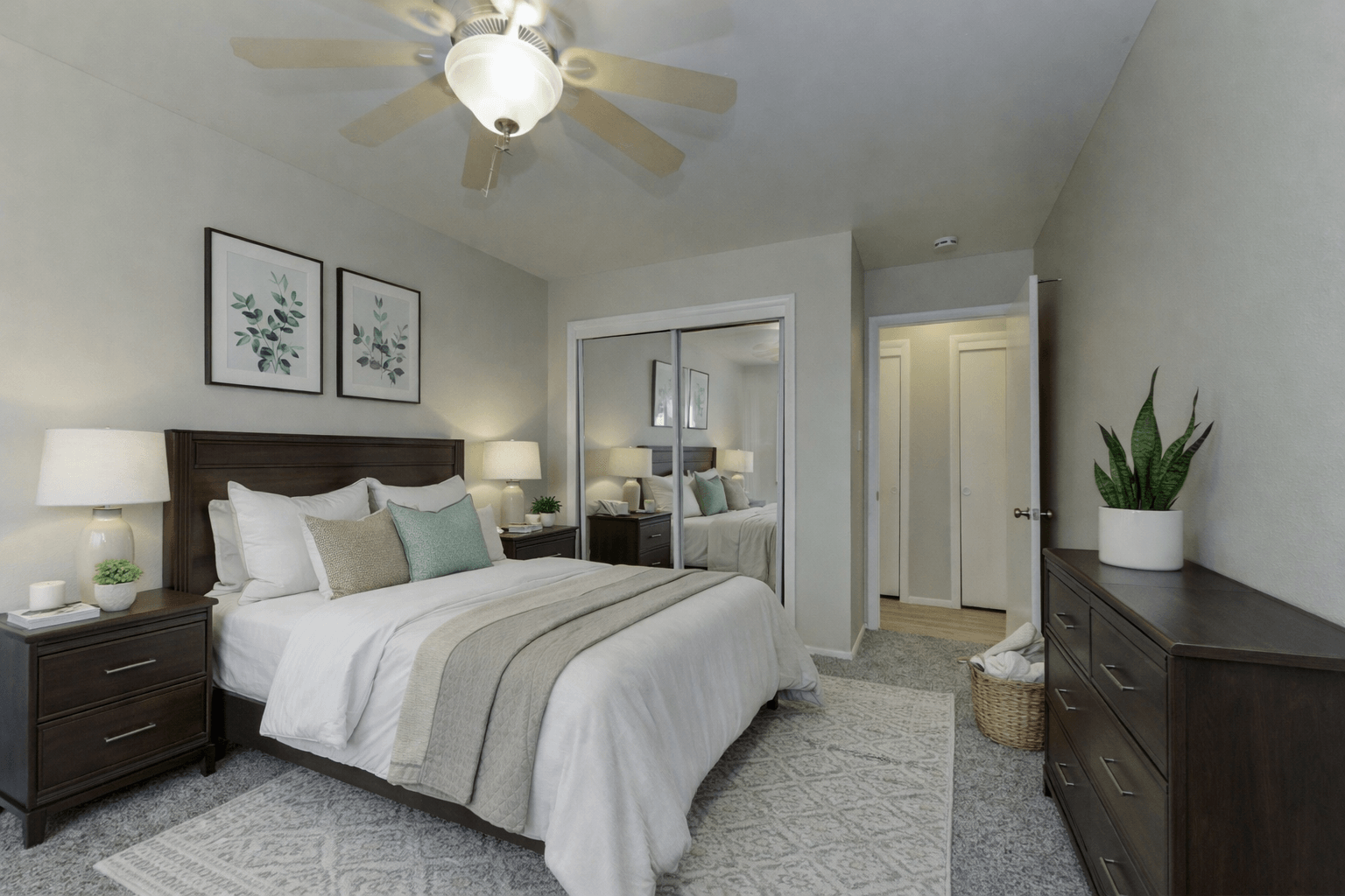 A bedroom with a large bed and a ceiling fan.